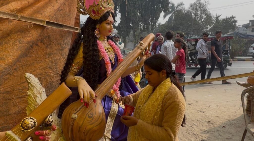 मूर्ती में रंग भरती महिला मूर्तिकार।