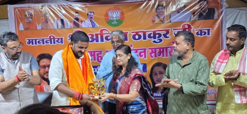 अनिल ठाकुर के स्वागत सह अभिनंदन समारोह के दौरान मंच पर उन्हें ओम् (Om) का स्मृति चिन्ह और भगवा अंगवस्त्र भेंट करती पिंकी गुप्ता, डॉ. अनिल कुमार गुप्ता व अन्य।
